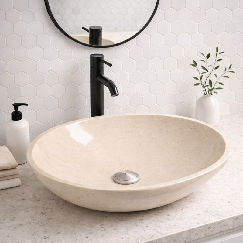 Unique bathroom sink featuring a handcrafted round beige marble vessel in an elegant bathroom setting.