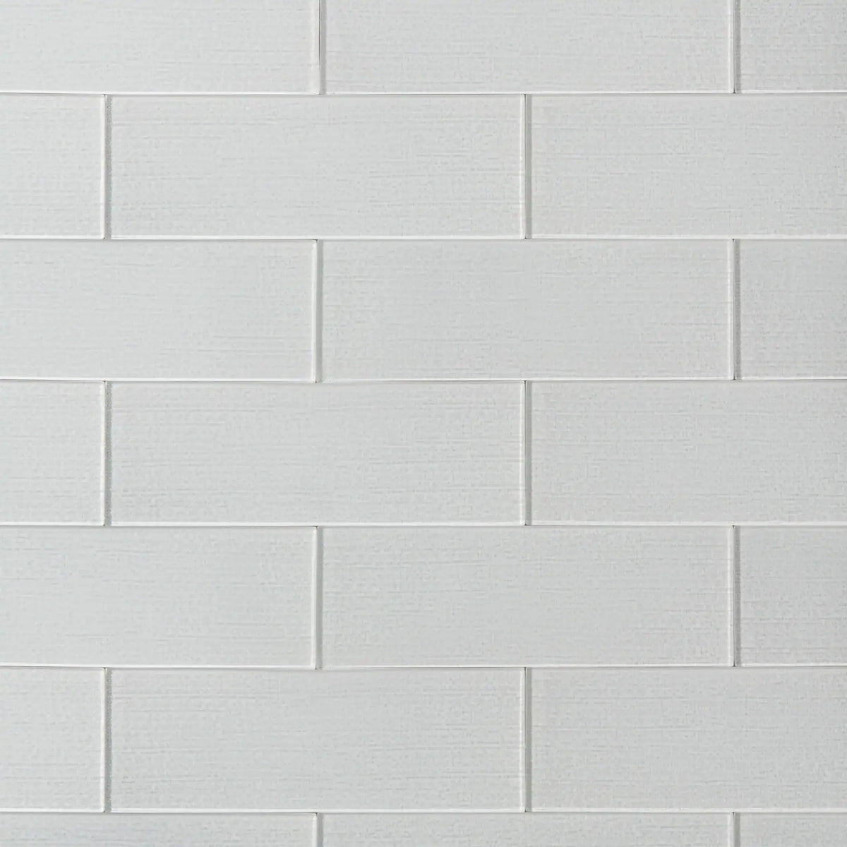 Linen ice 4-in x 12-in glass wall tiles with reflective surface, ideal for modern kitchen backsplashes and bathroom walls.