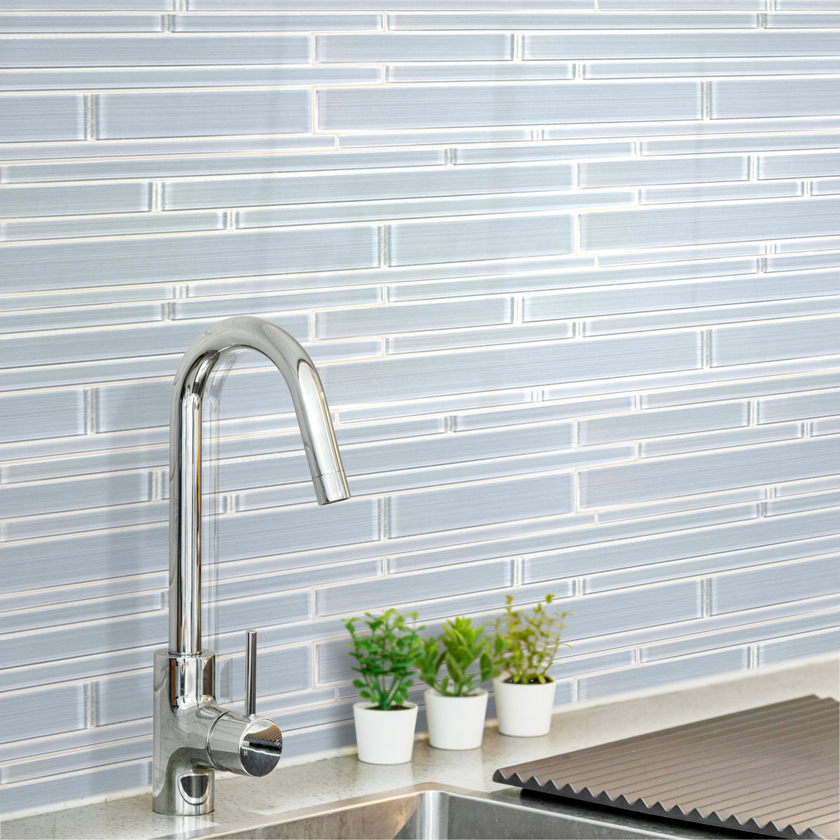 Contemporary kitchen wall featuring Ice Denim 6x18 glass mosaic tiles – mixed glass strips creating a sleek, cool look.