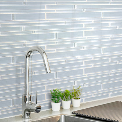 Contemporary kitchen wall featuring Ice Denim 6x18 glass mosaic tiles – mixed glass strips creating a sleek, cool look.