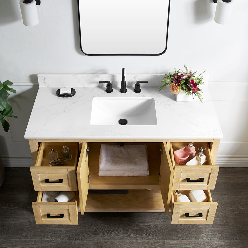 Natural oak vanity base with a white sink, drawers open, plants, and modern faucets in a stylish bathroom setting.
