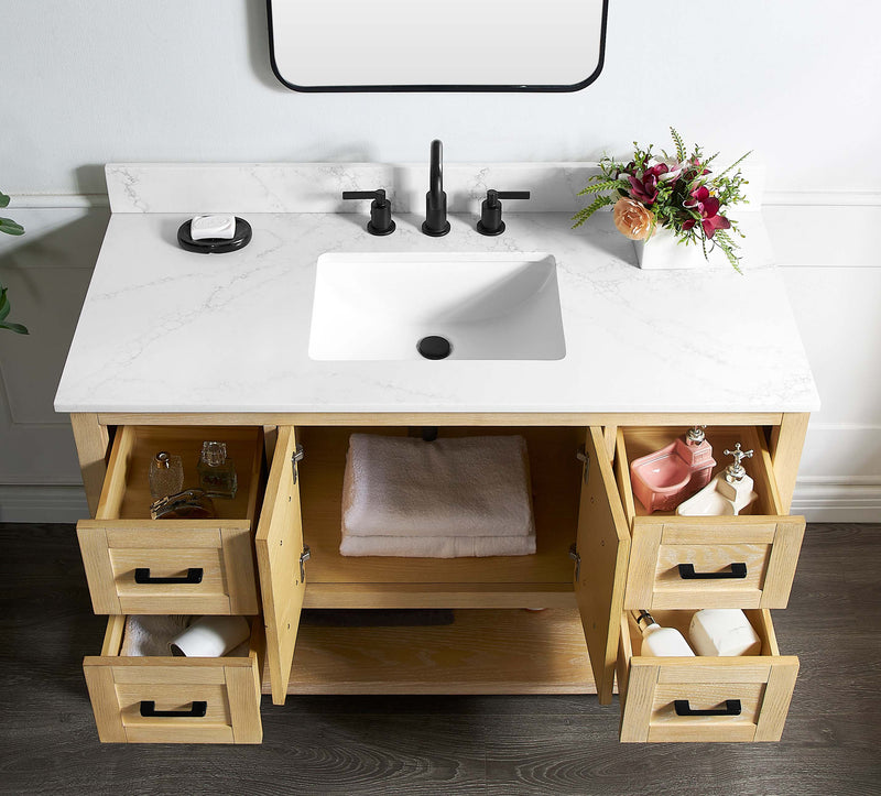 Natural oak vanity base with marble countertop and open drawers in a stylish bathroom setting.