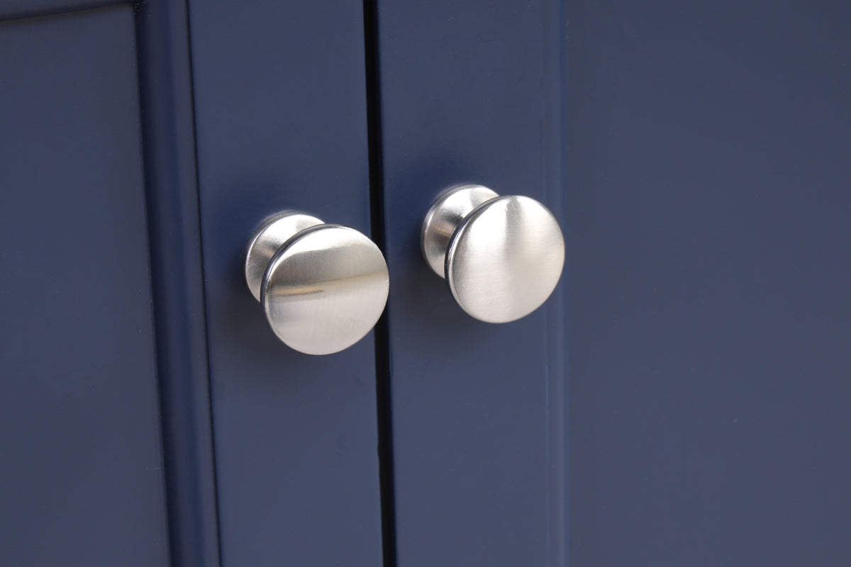 Close-up of modern cabinet knobs on a navy blue bathroom vanity.