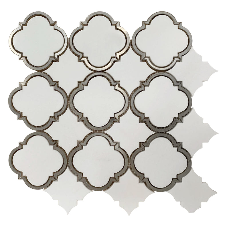 Close-up of Thassos Marble Waterjet Mosaic with Patterned Metal Trim – elegant polished tile combining luxury stone and metallic accents
