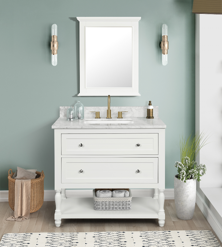 Dove white framed bathroom vanity mirror above white sink with gold fixtures in elegant bathroom setting.